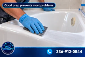 Technician preparing a white bathtub surface with a sanding pad before refinishing